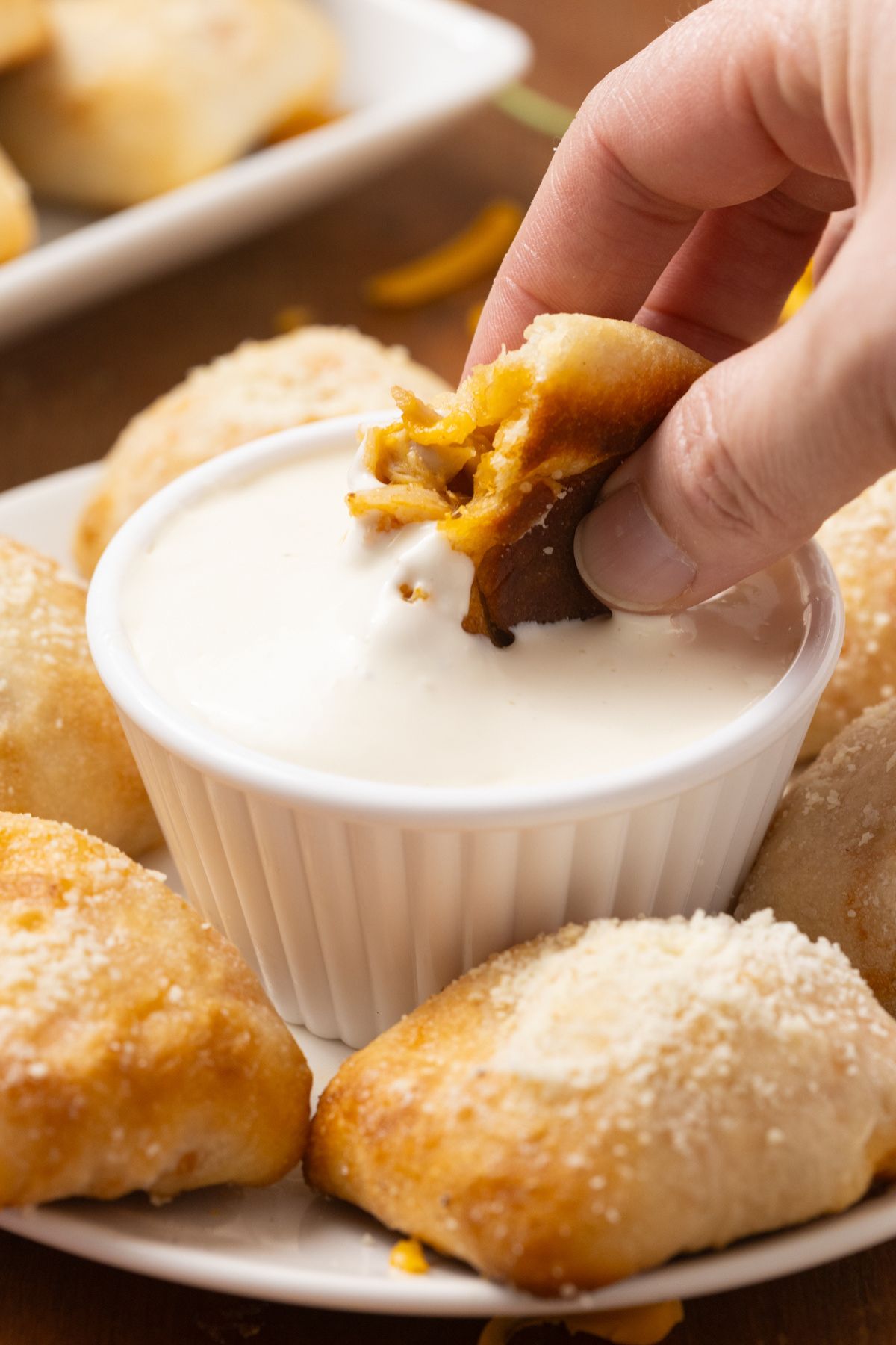 A piece of buffalo chicken bites being dipped into ranch dressing