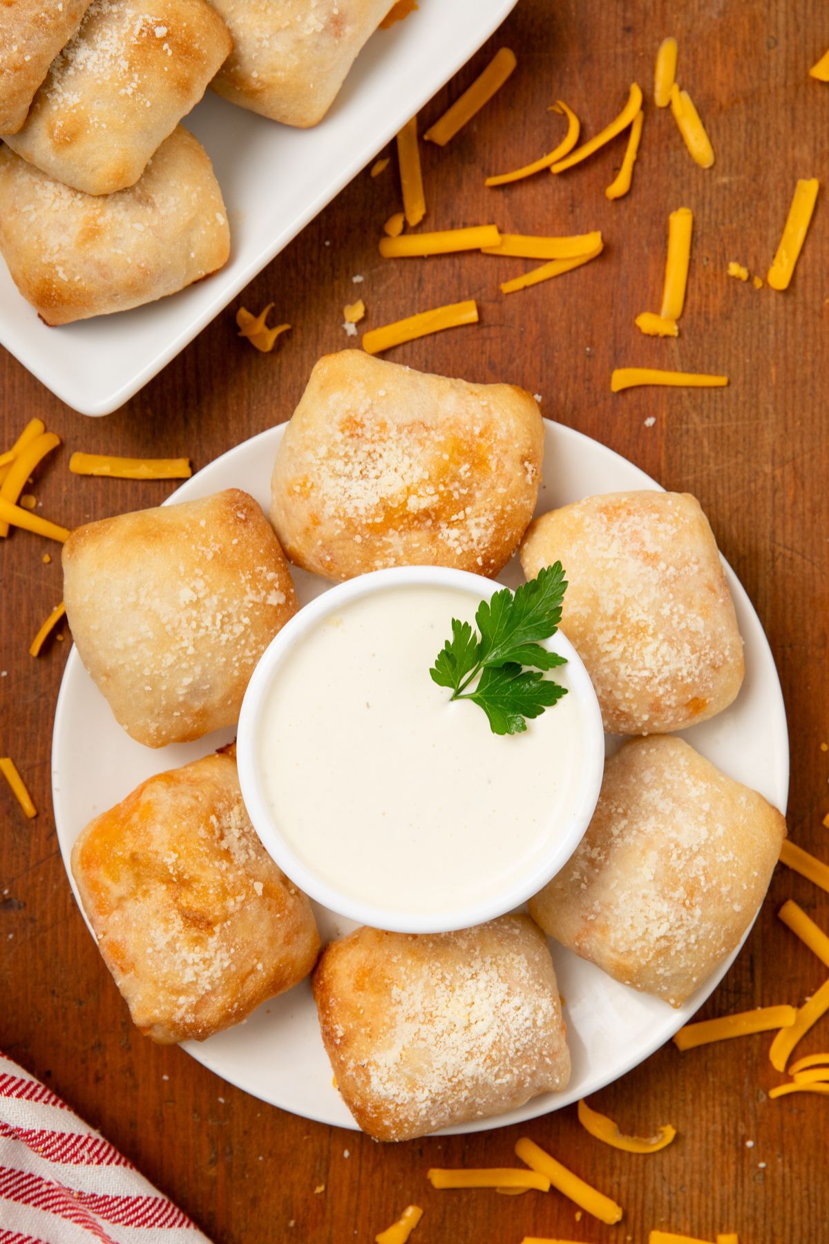 Six buffalo chicken bites on a white plate with ranch dressing. in the middle.