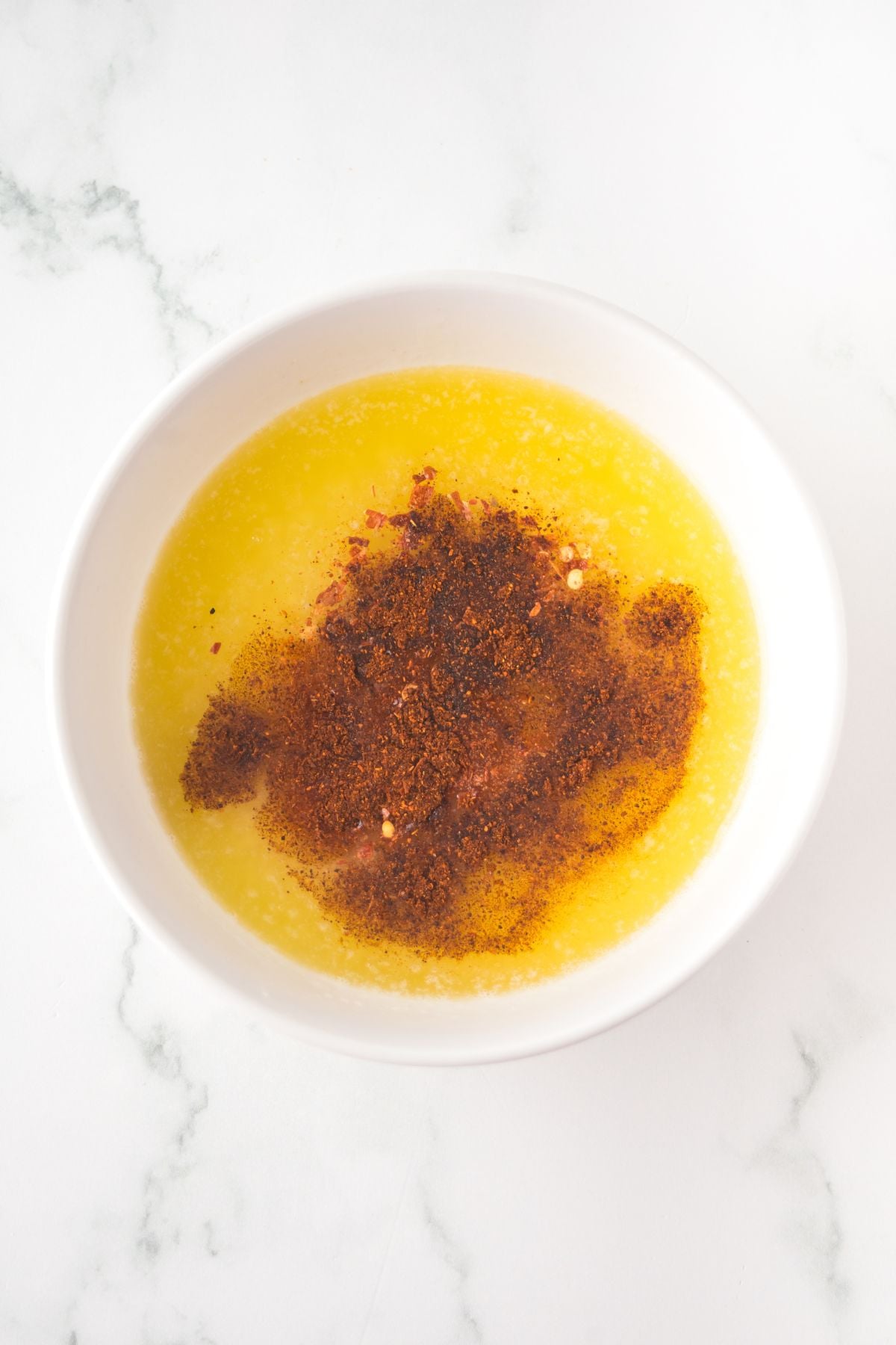 All of the ingredients necessary to make a hot honey glaze in a bowl on a table.