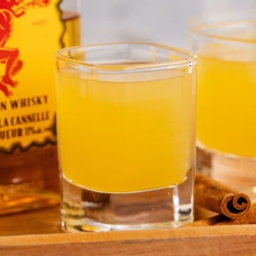 Apple Pie Shots on a serving tray with bottle of whiskey.