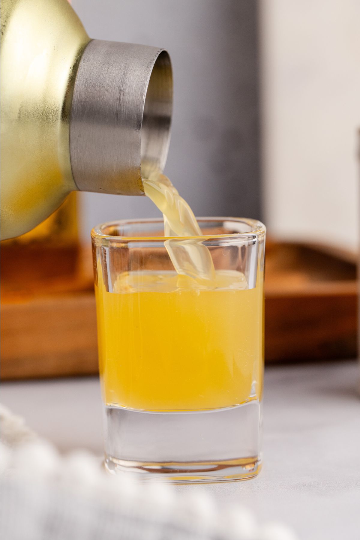Drink poured in shot glass from shaker.