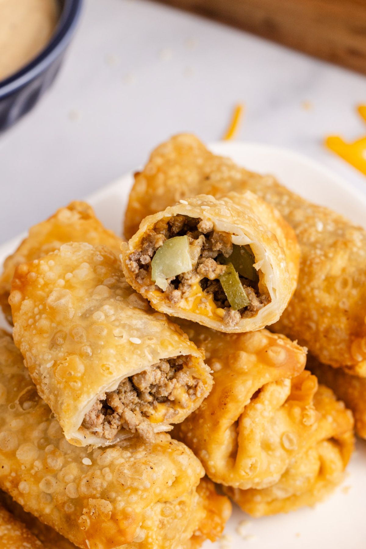 Big mac egg roll cut in half and stacked on top of other egg rolls.
