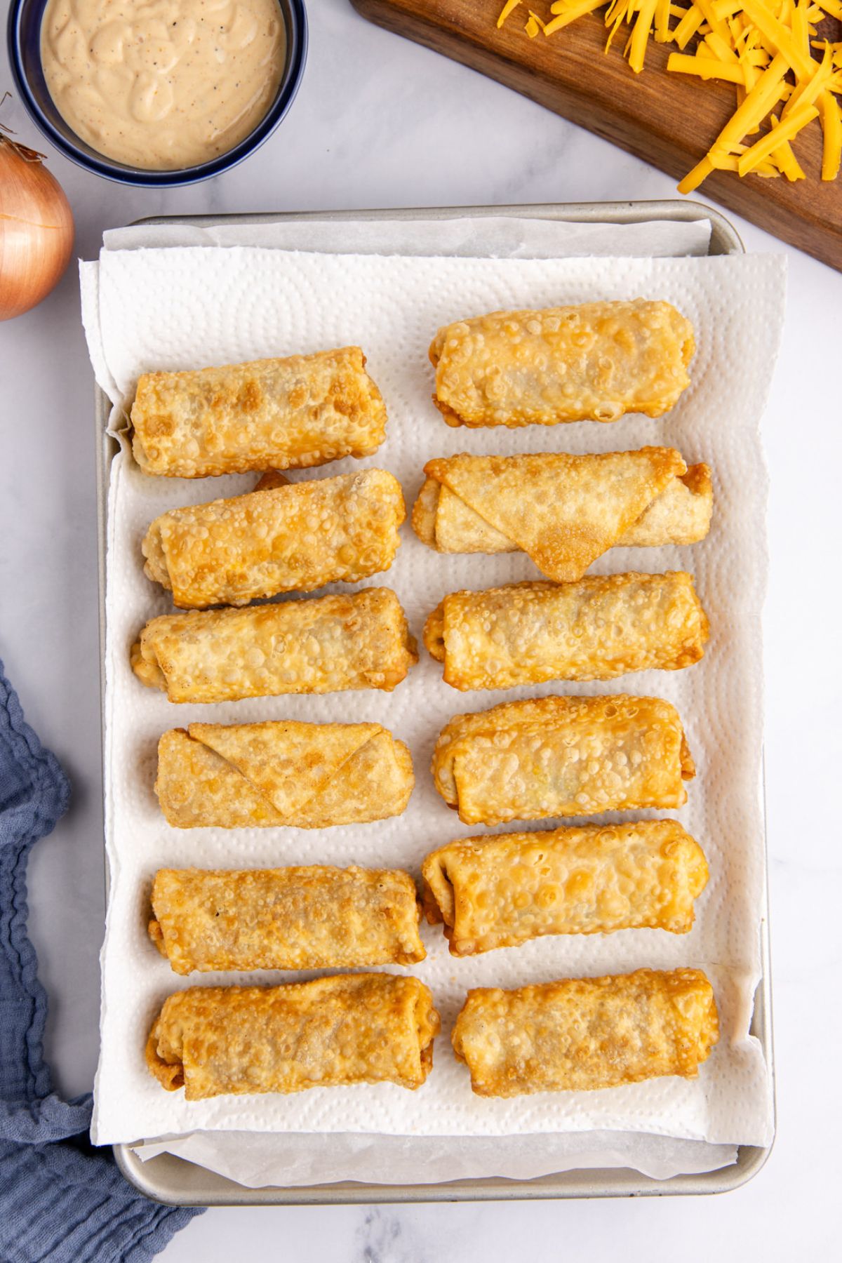Egg rolls put onto a paper towel-lined plate to soak up excess oil.