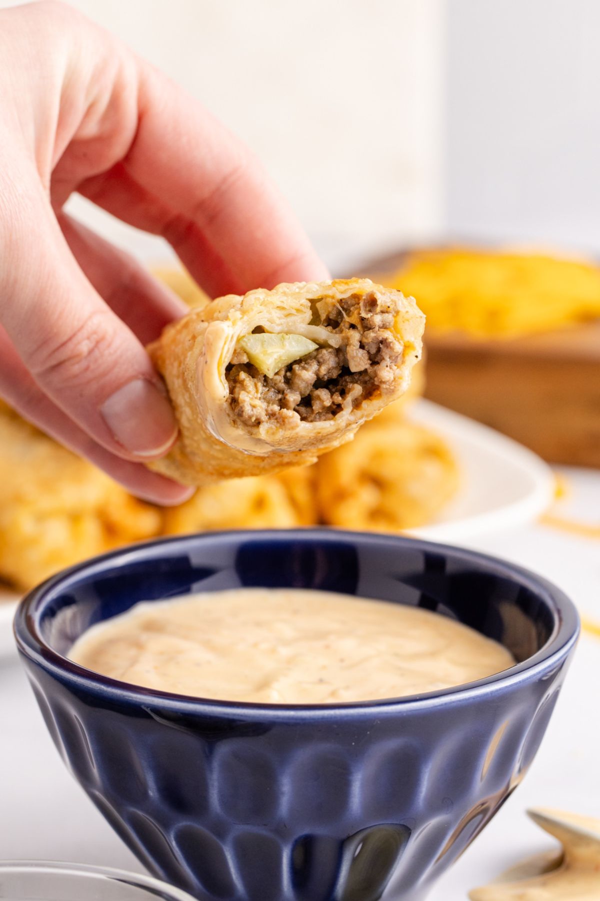 Big Mac egg roll with a bite taken, ready to dip in sauce.