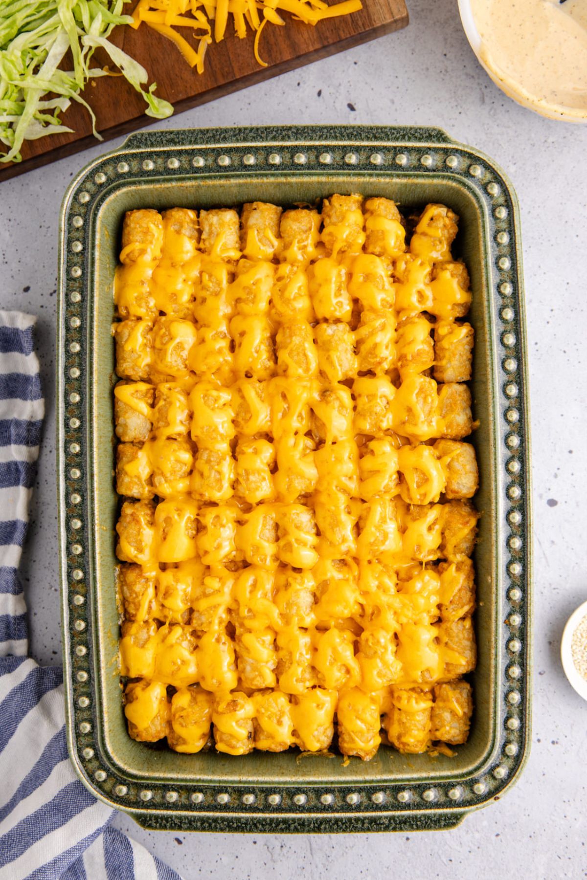 Cheese on top of tater tots and beef mixture.