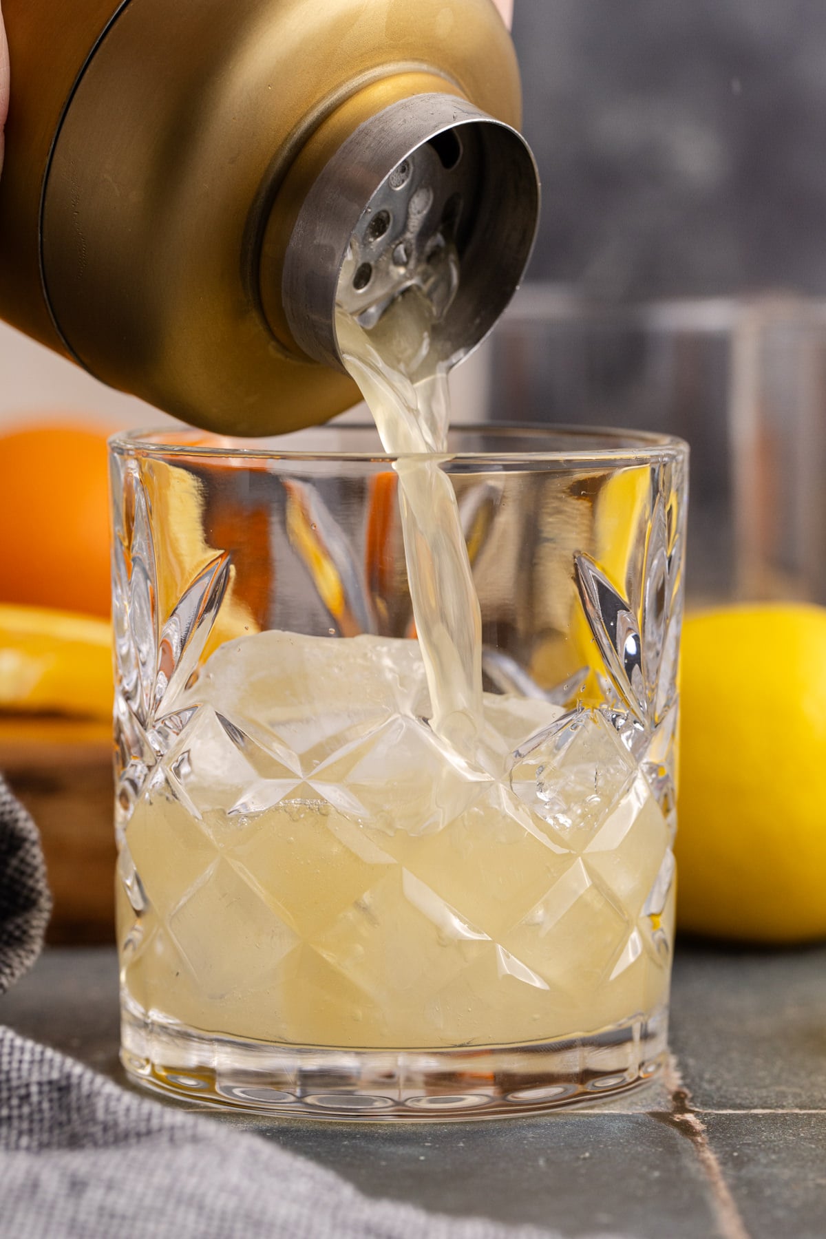 The cocktail sharing pouring drink into glass.