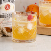 A bourbon lemon cocktail served with a cherry garnish.