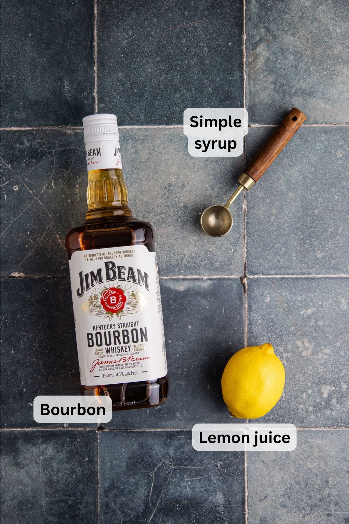 All of the ingredients needed to make a bourbon lemon cocktail on a counter.