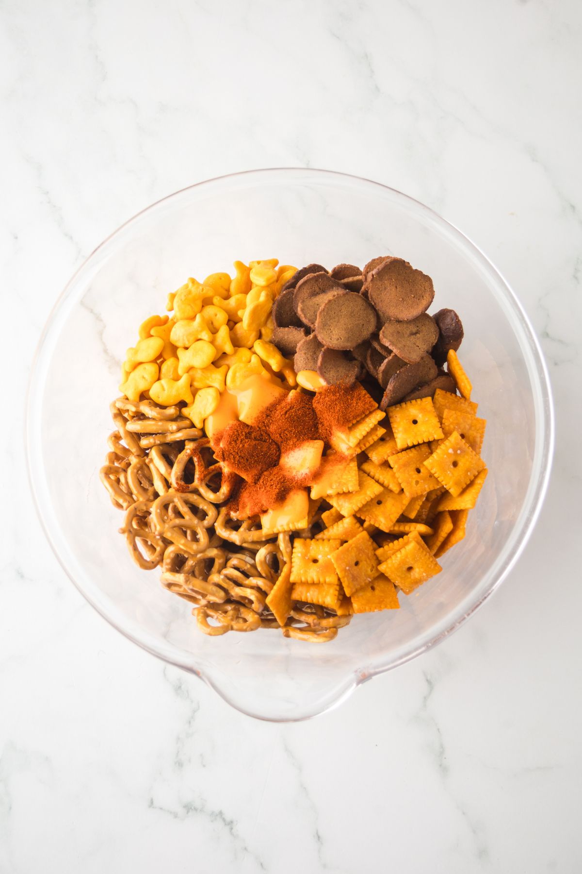All the ingredients in a bowl with buffalo sauce on top ready to be mixed.