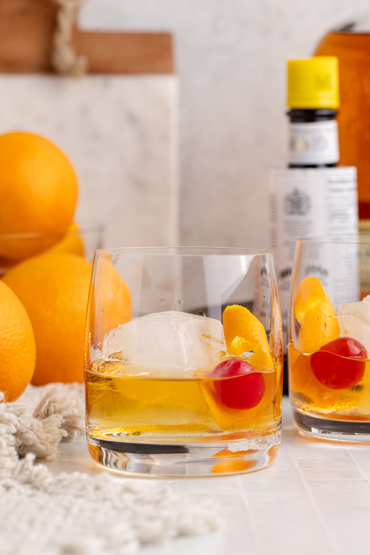 old fashioneds on table with ingredients.
