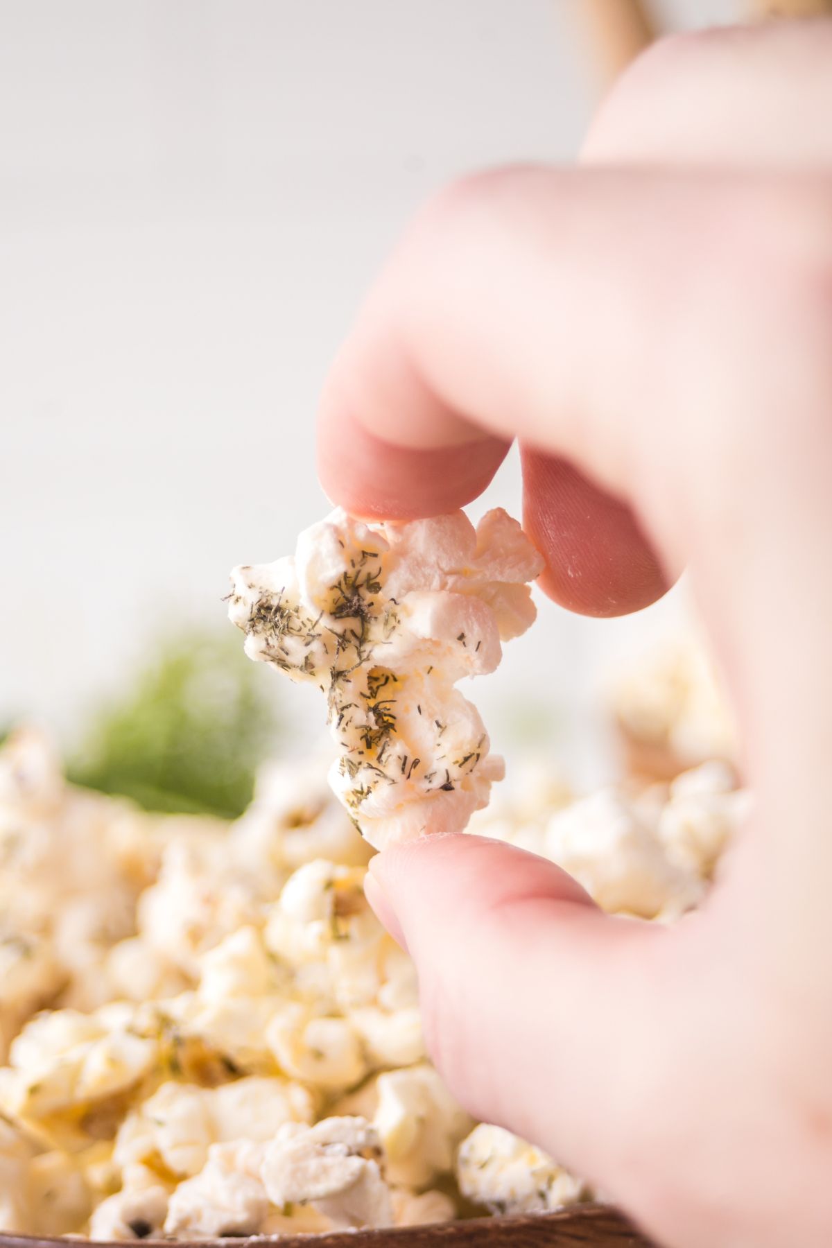 A piece of popcorn held in the air.