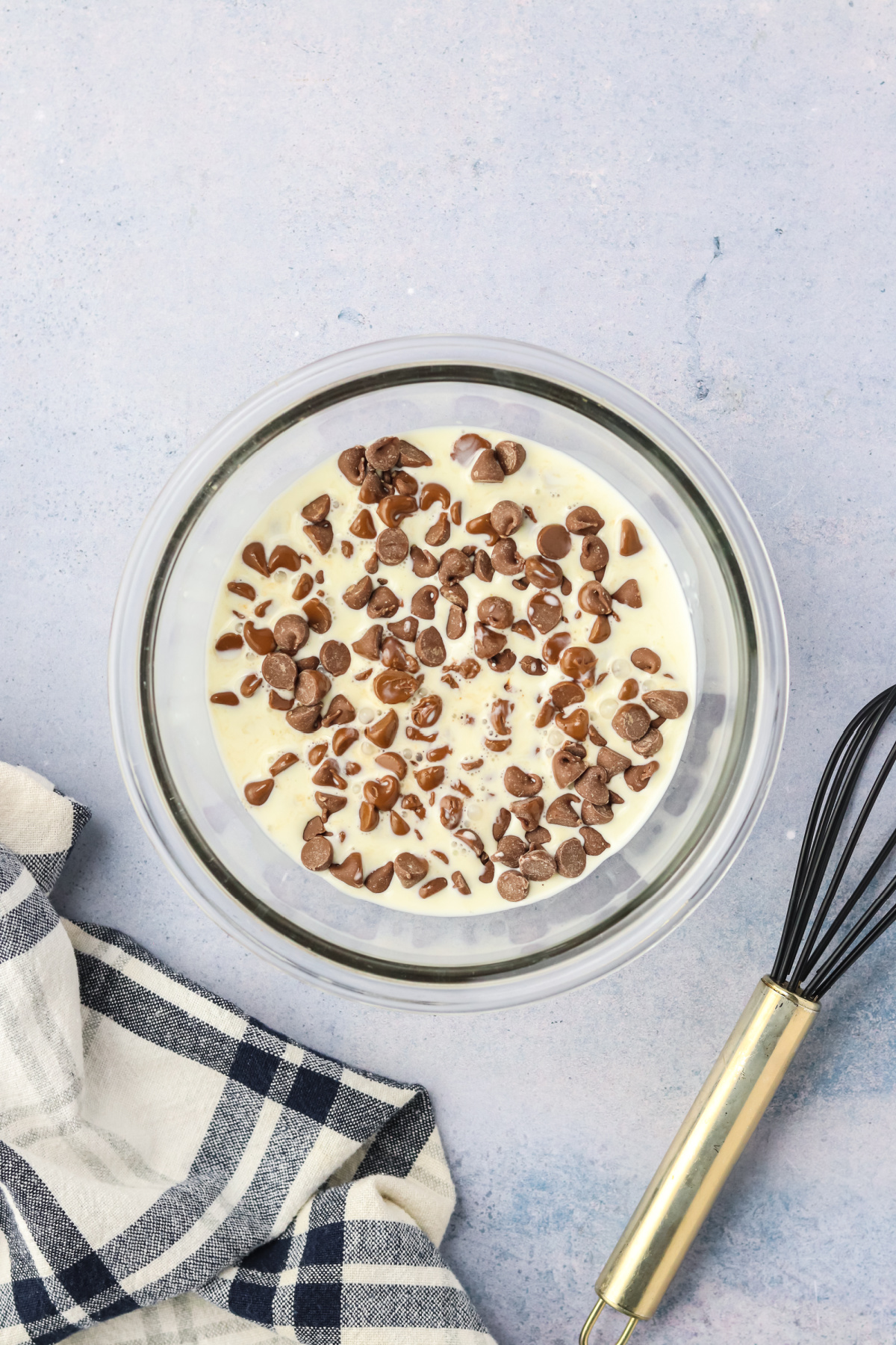 Heavy cream and chocolate chips in a small mixing bowl.