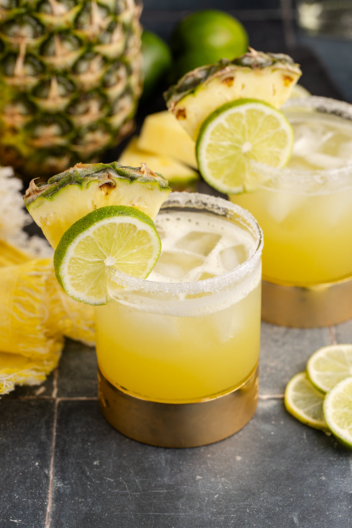 Cocktail served with garnish of pineapple and lime.