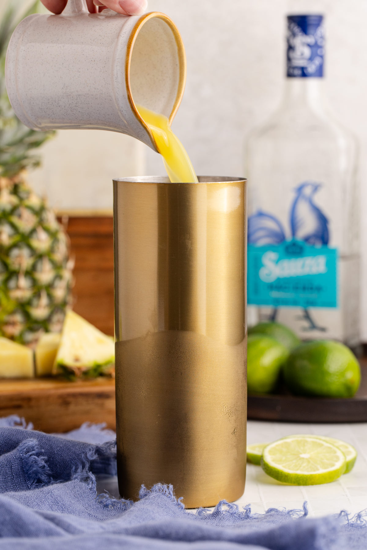 Pineapple juice, triple sec, and margarita mix into the shaker.