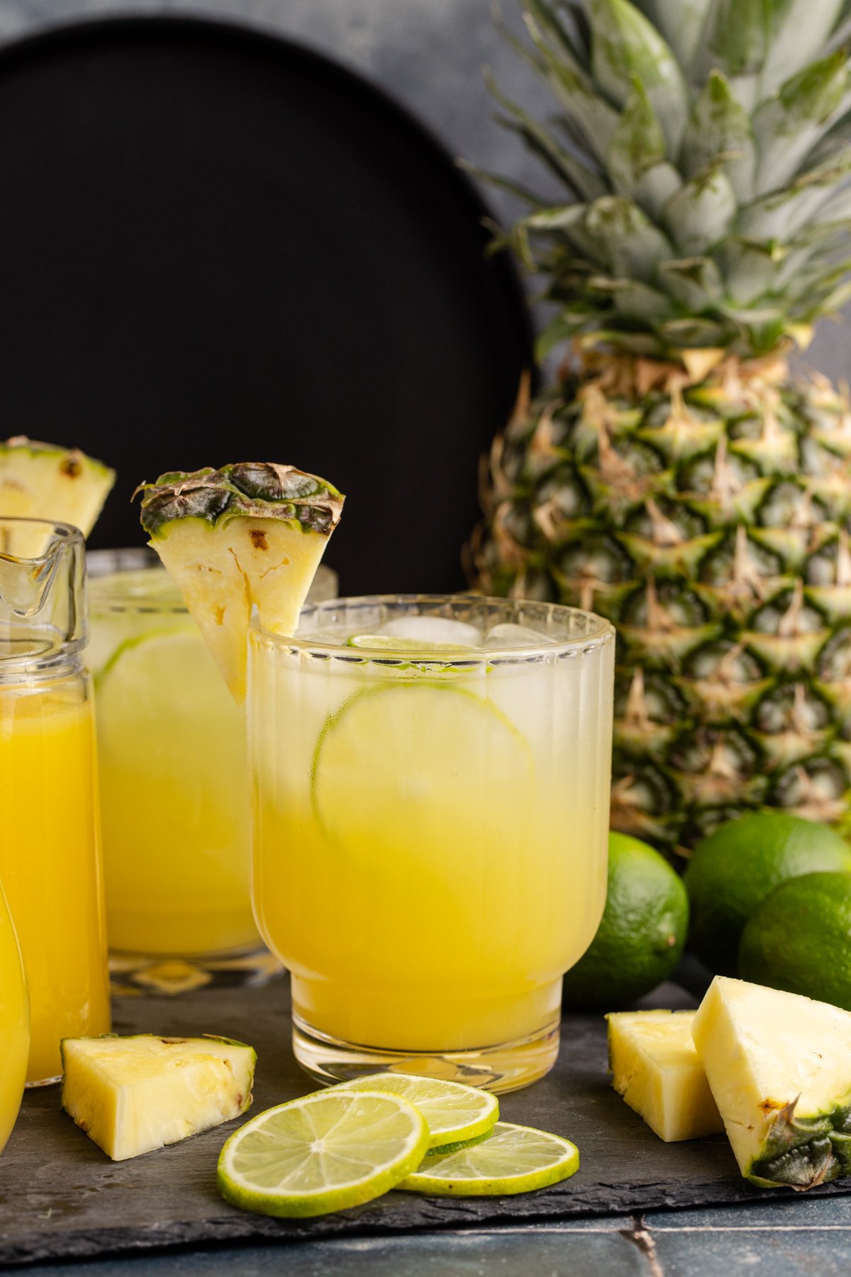 Pineapple rum cocktail in a glass with a pineapple garnish and lime inside.