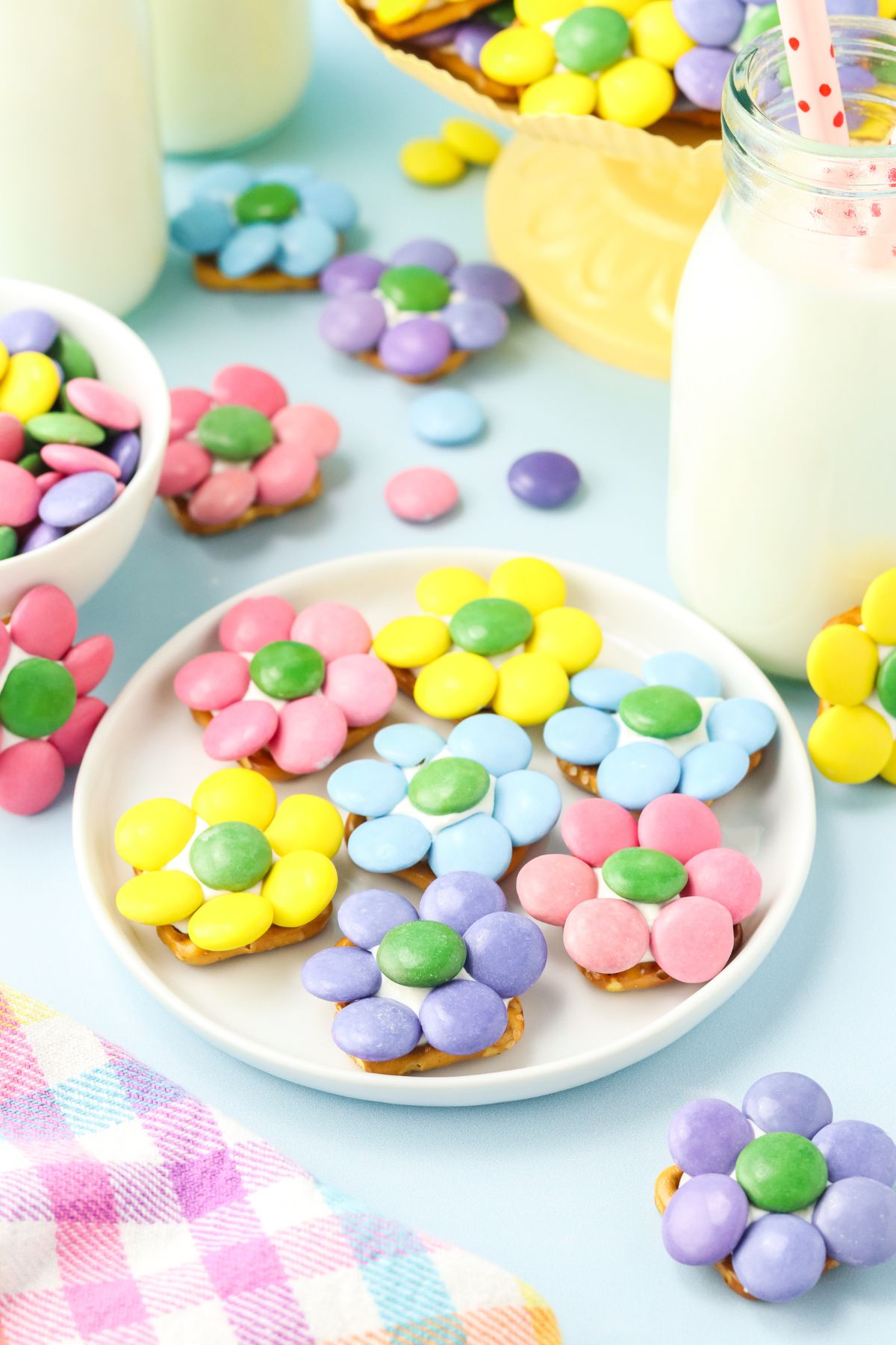 A plate of flower shaped M&M over pretzels and candy melts.