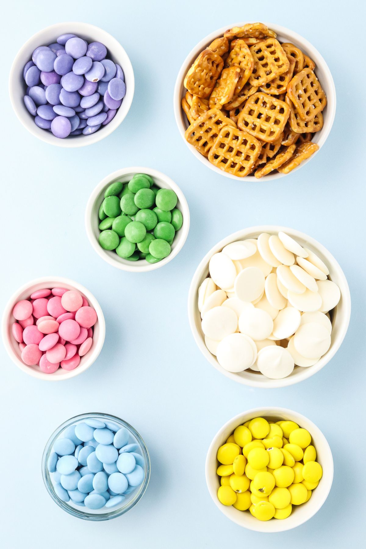 Ingredients to make pretzel flowers in bowls on a table.