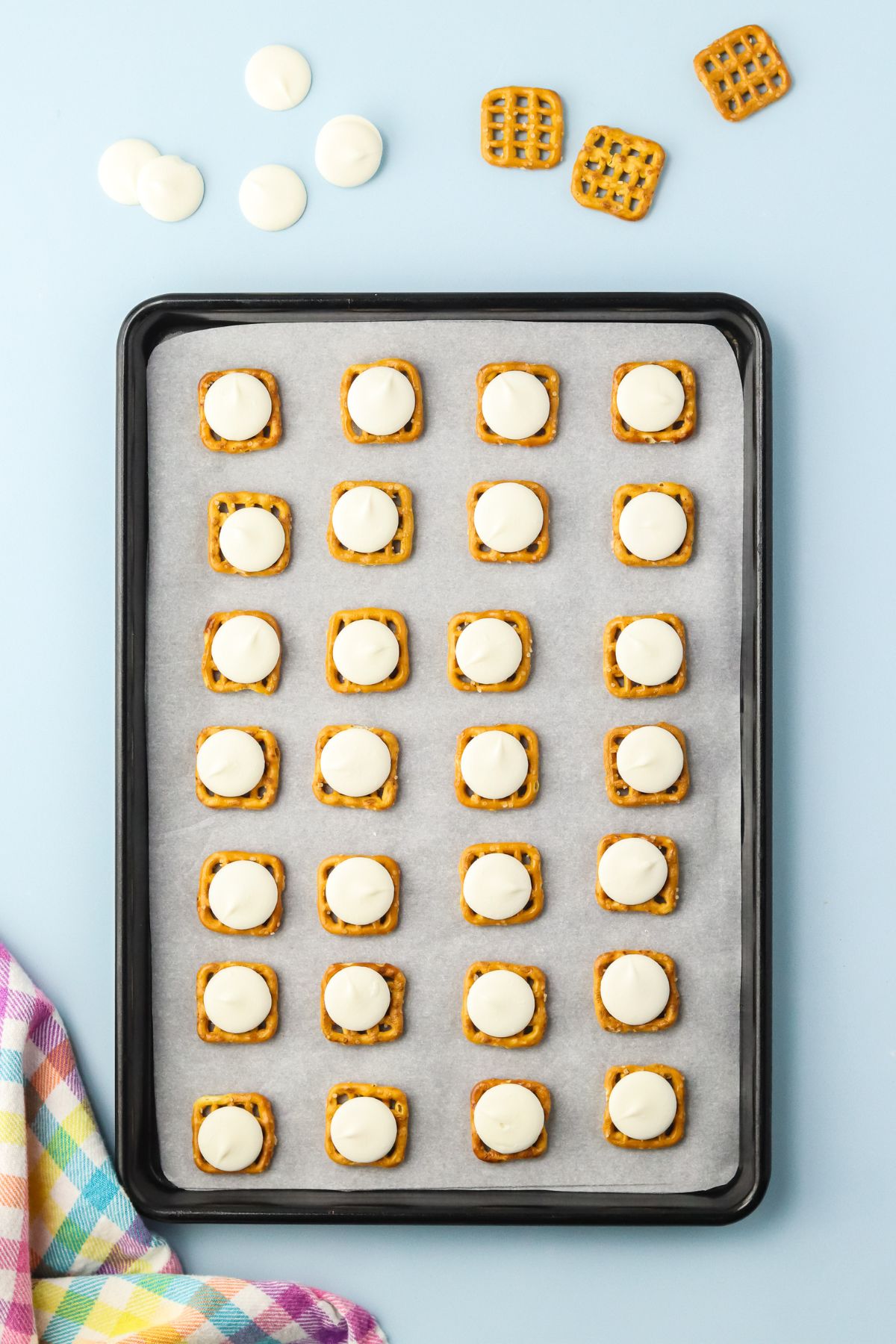 Waffle pretzels onto a lined baking sheet with a candy melt on top.