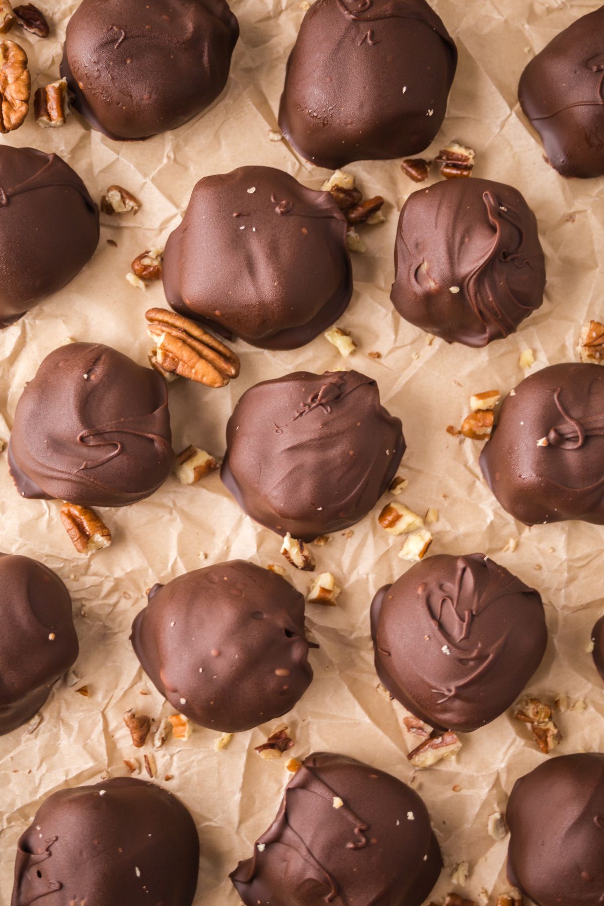 Chocolate covered caramel pretzels on parchment paper.