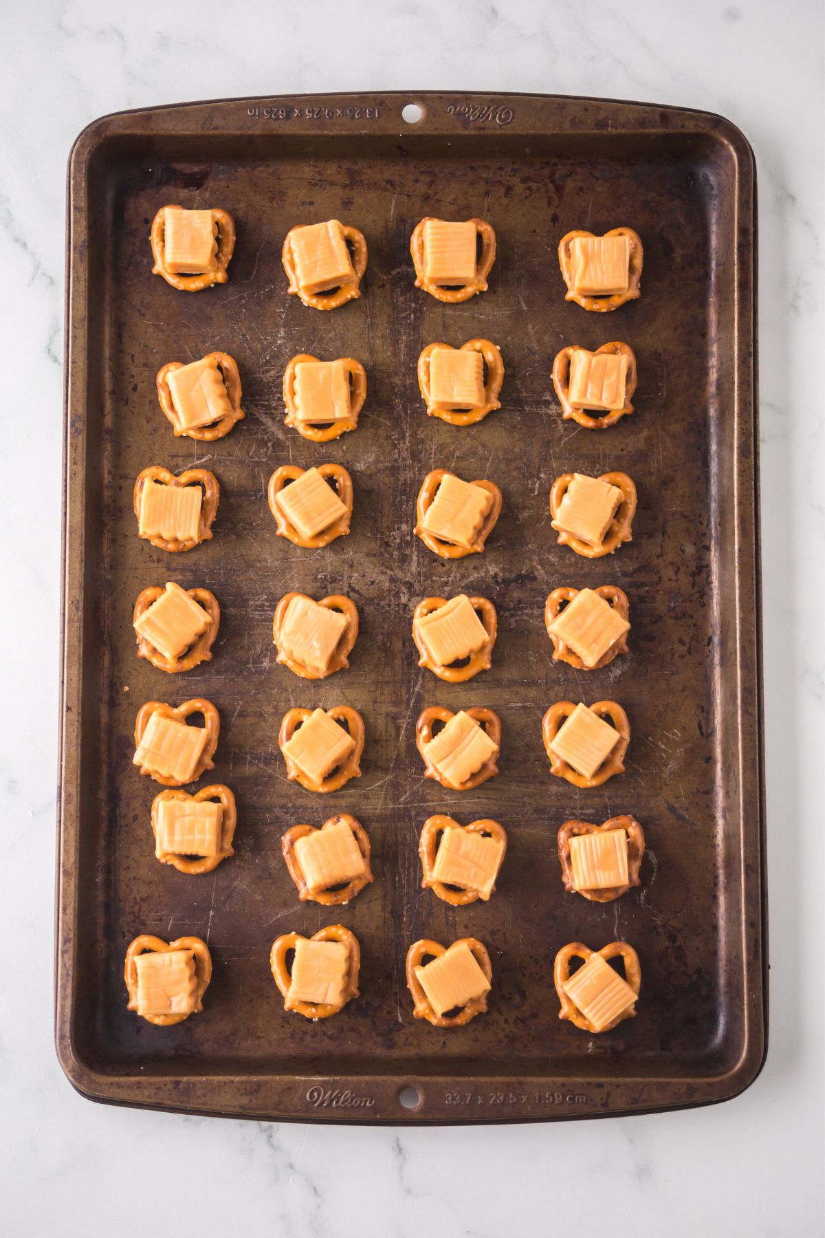 Pretzel twists arranged in a single layer on the baking sheet. 