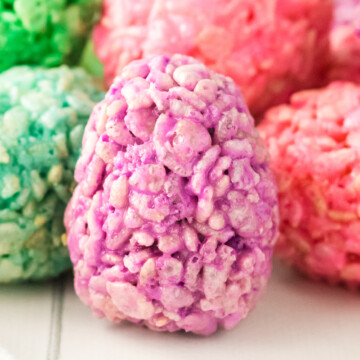 A bunch of rices krispie eggs piled on a table.