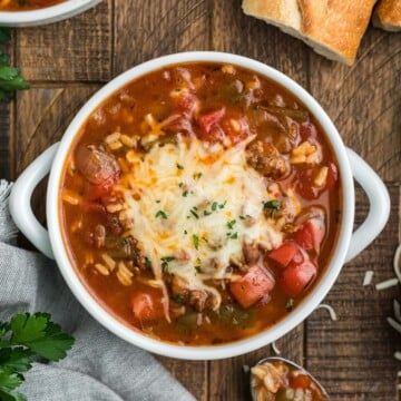 Stuffed bell pepper soup in a bowl topped with melted cheese.