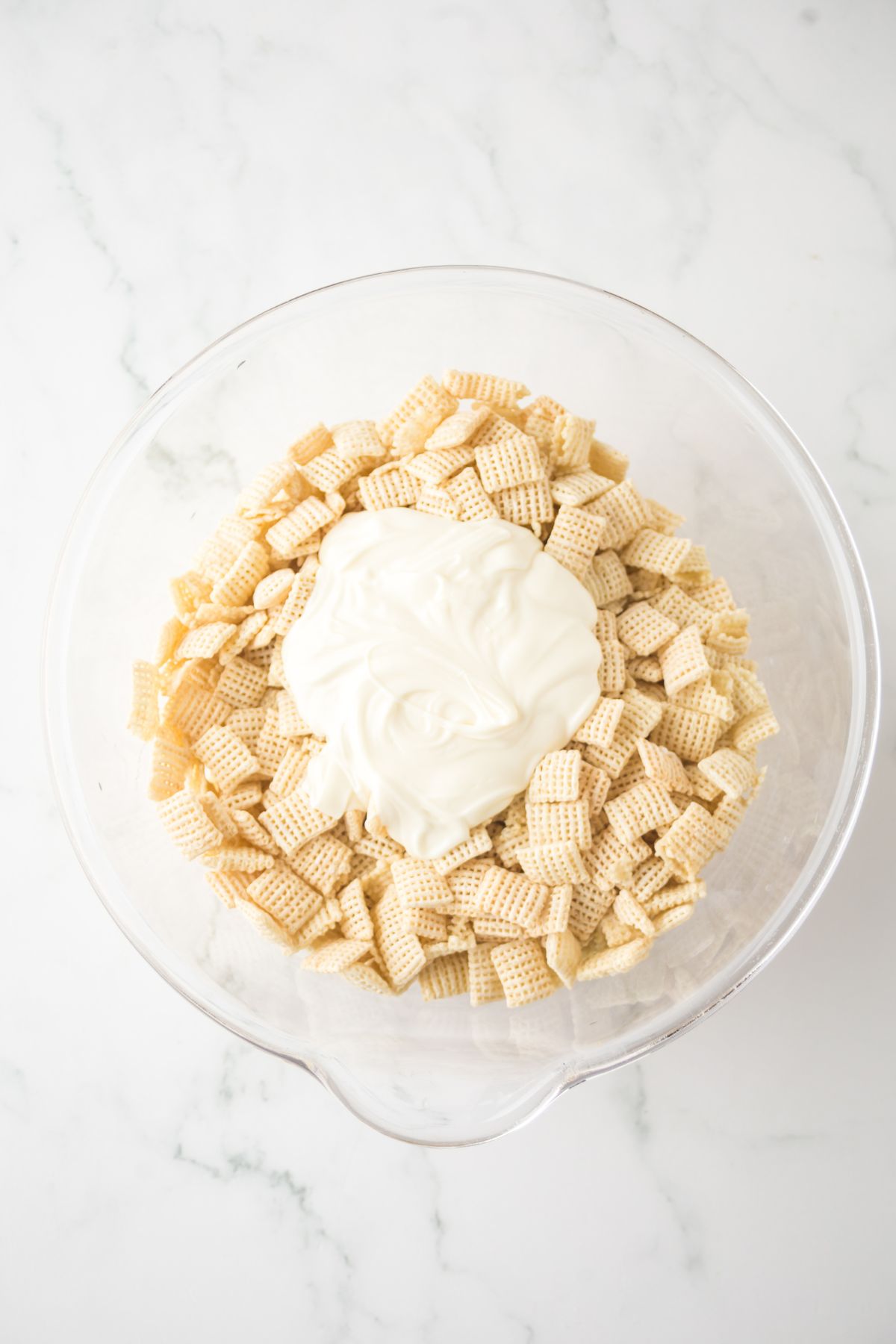Chex cereal with melted chocolate in a bowl.