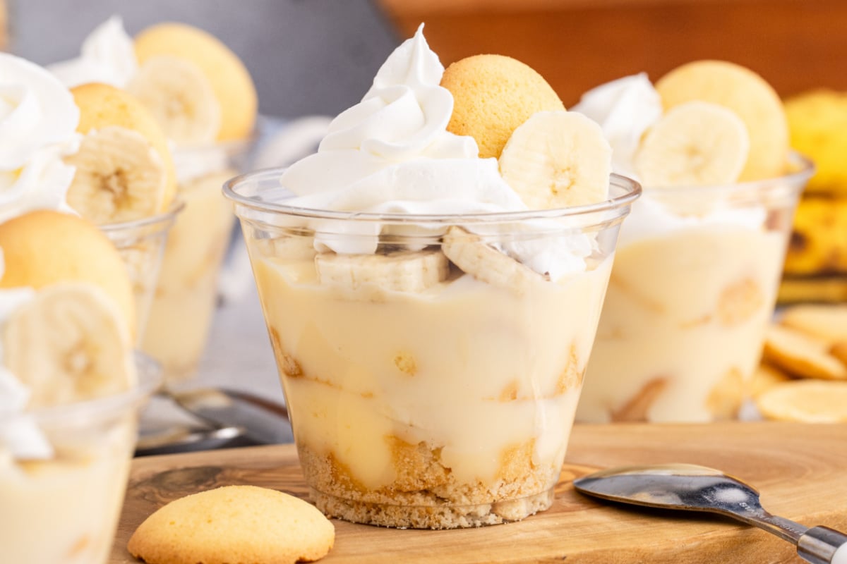 Banana pudding cups on a cutting board.