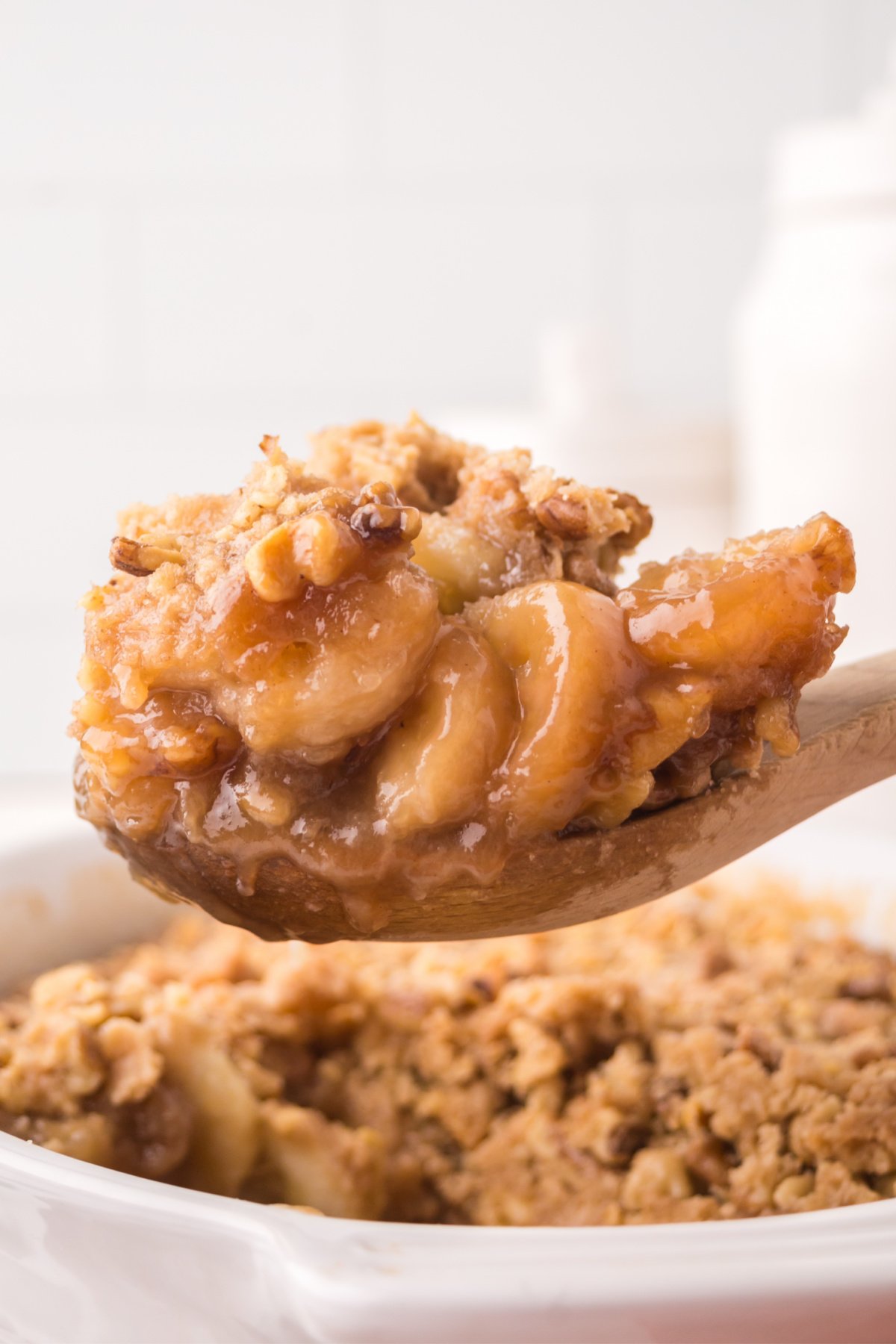Banana cobbler on a wooden spoon held up in the air.
