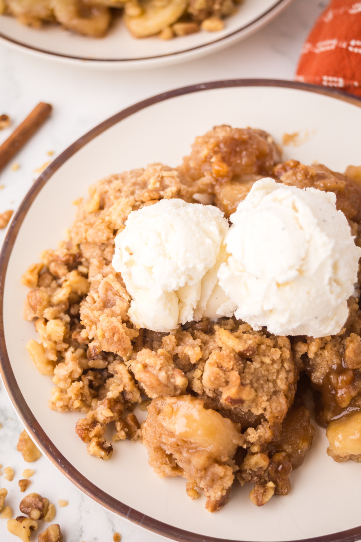 Banana cobbler on a plate with two scoops of ice cream on top.