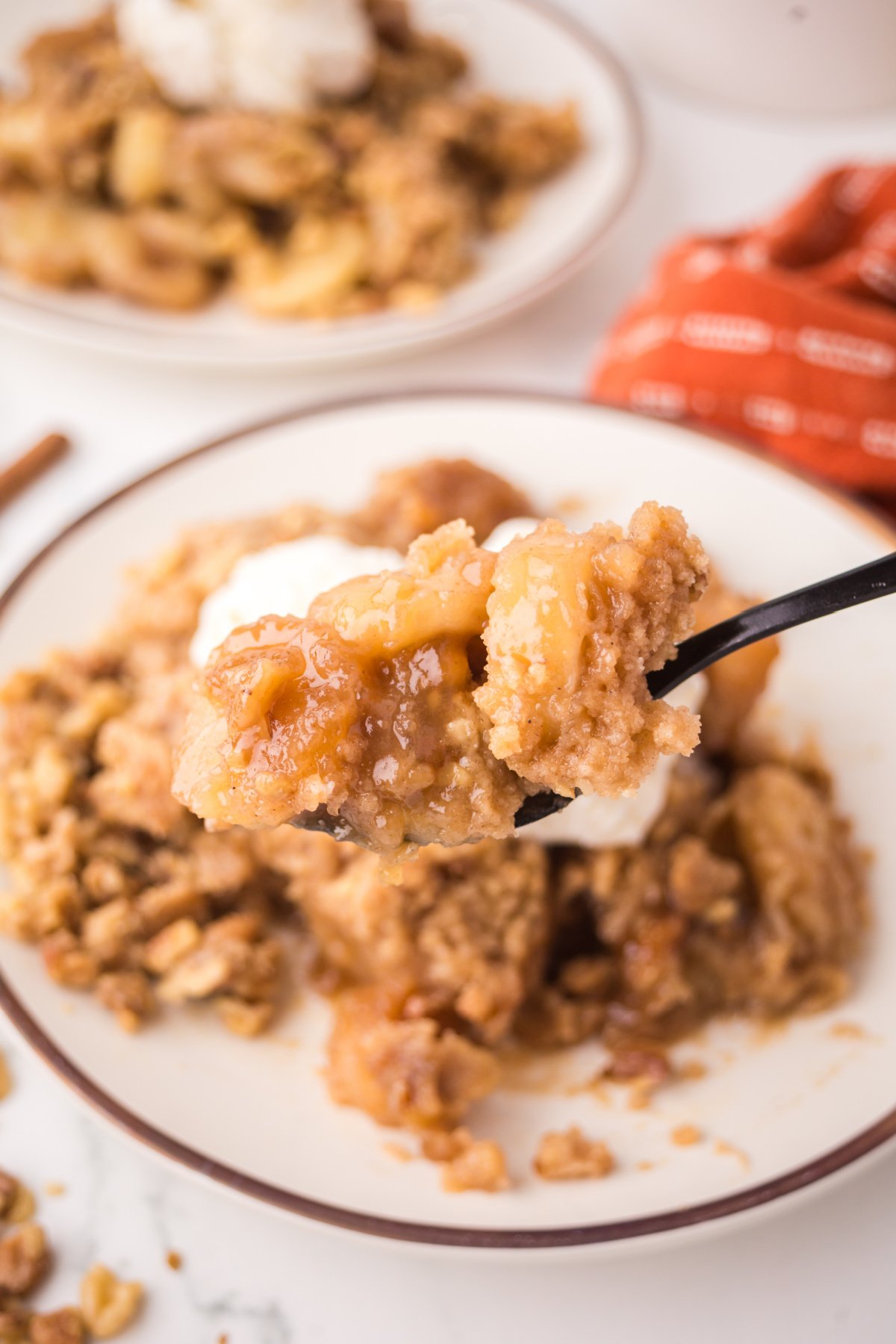 A fork full of cobbler with bananas held up in the air.