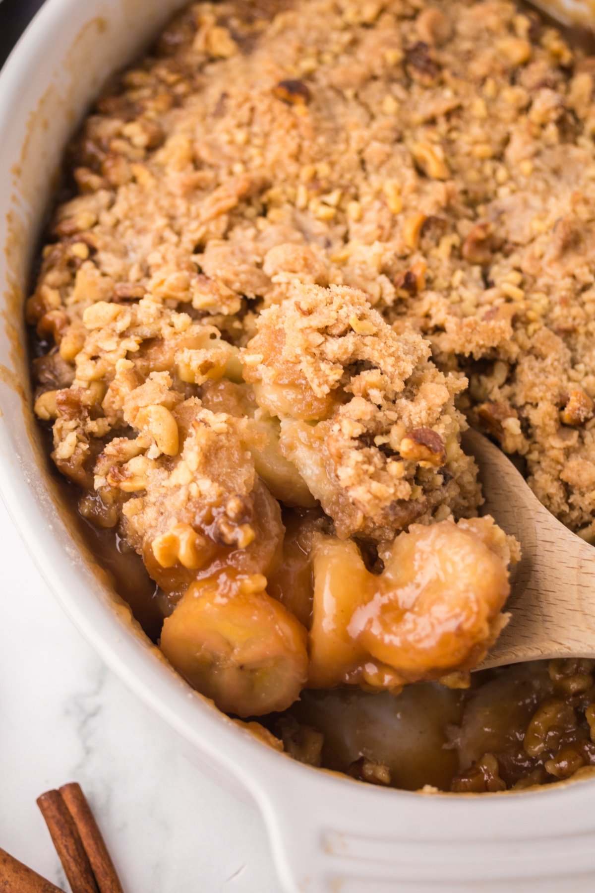 Finished cobbler with a wooden spoon scooping some out to serve.