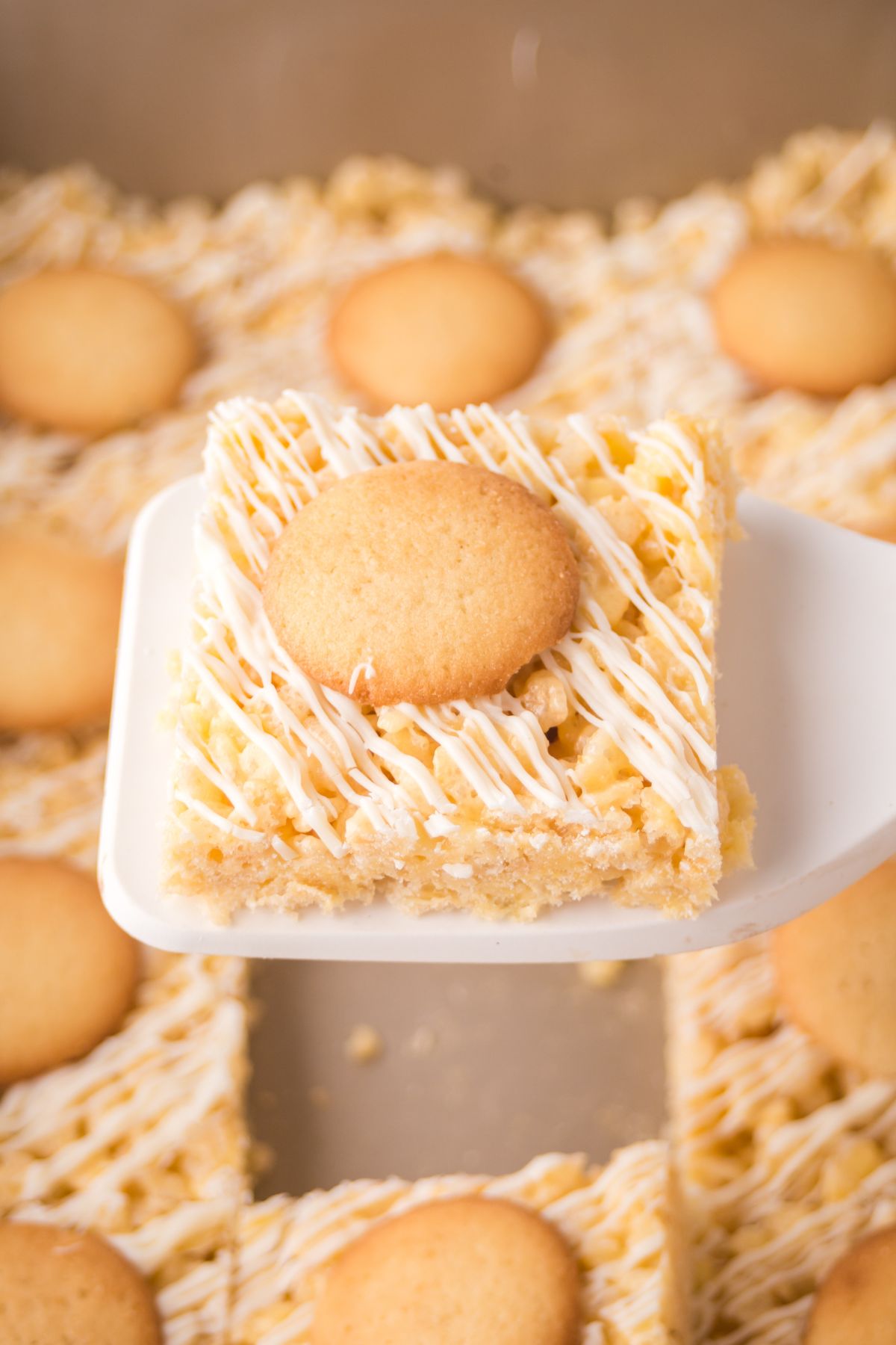 Banana rice krispie treat held up with a spatula. 
