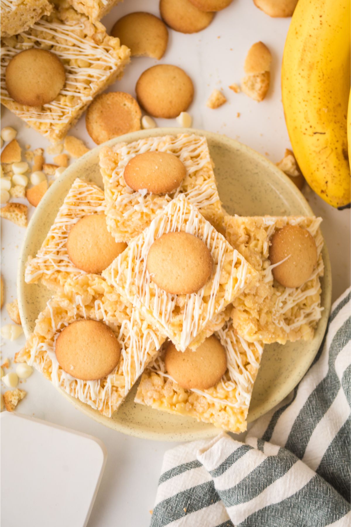 A plate filled with rice krispie treats with a cookie on top.