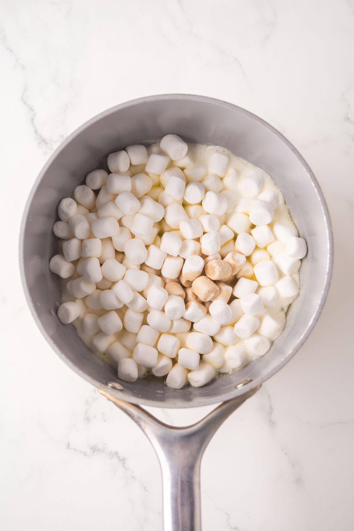 Marshmallows and butter melted in a saucepan.