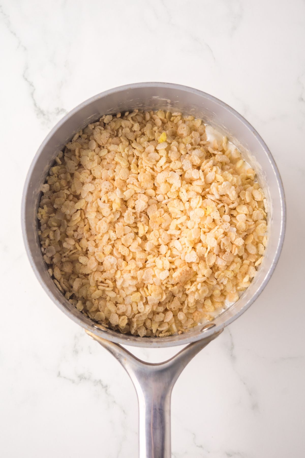 Banana pudding mix and rice krispies added into the saucepan.