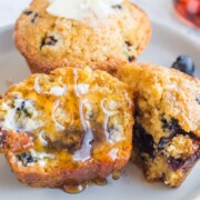 Blueberry Cornbread Muffins drizzled with syrup.