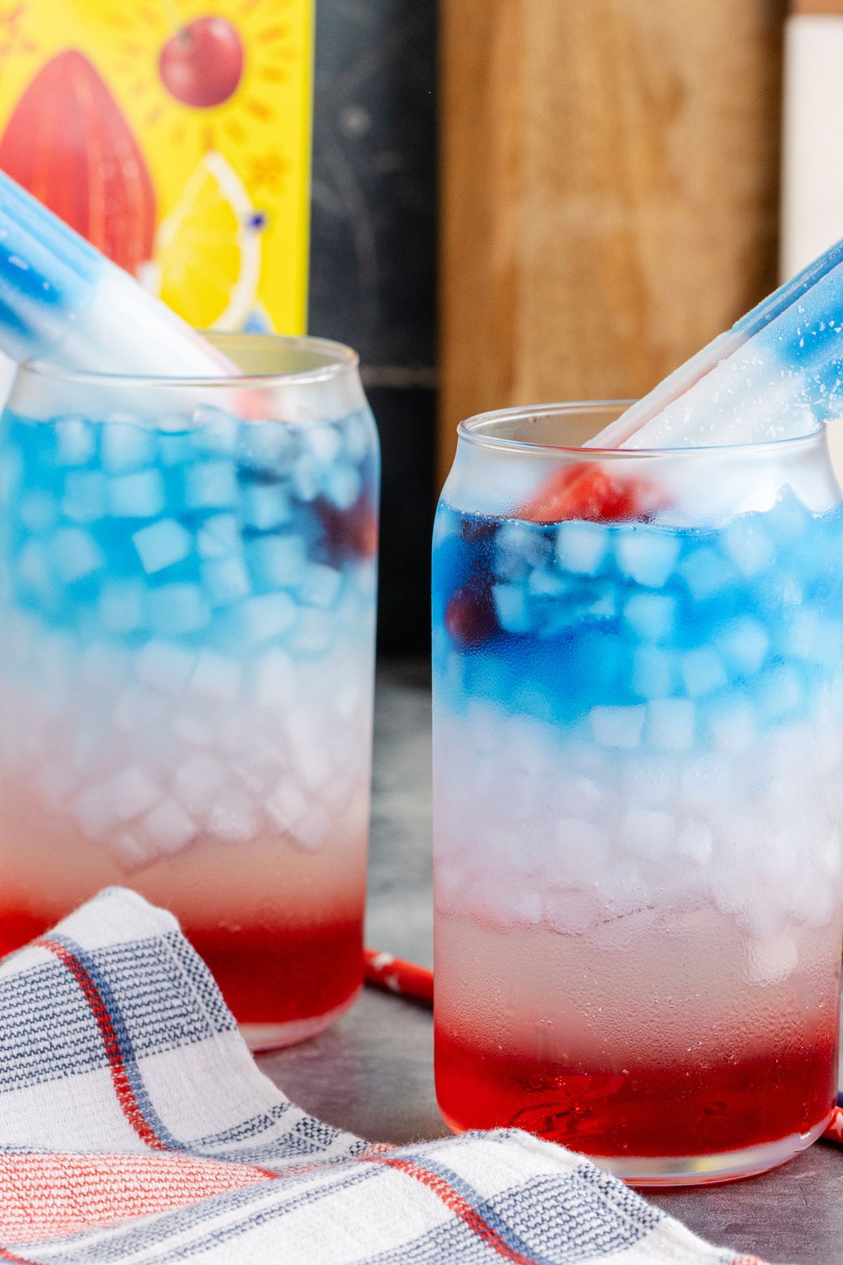 Two drinks beside each other with popsicles.