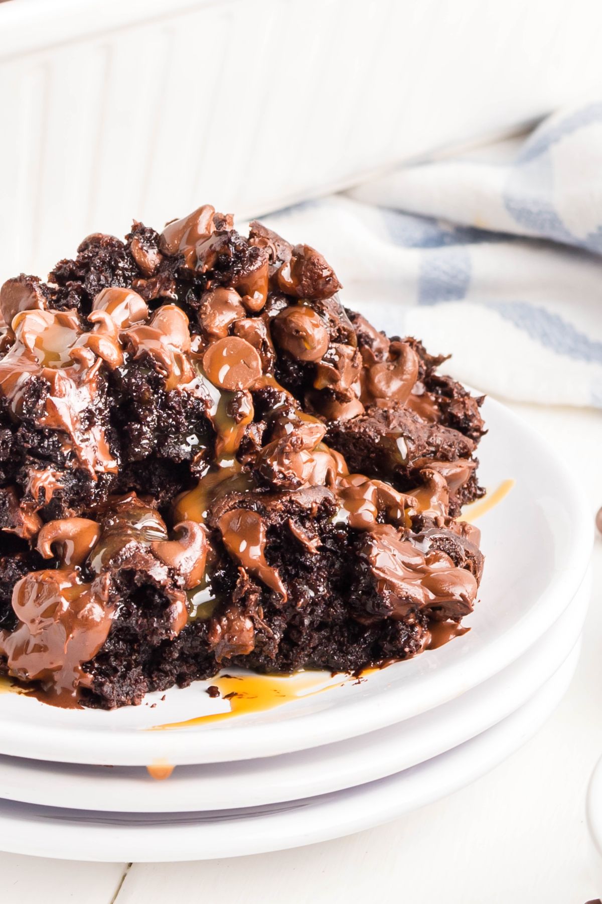 Some chocolate pudding cake with chocolate chips on a stack of plates.