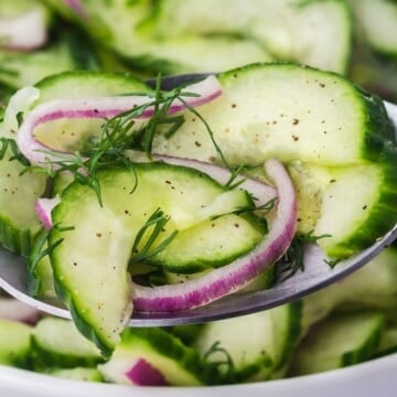 Cucumber Onion Salad being held up by a spoon.