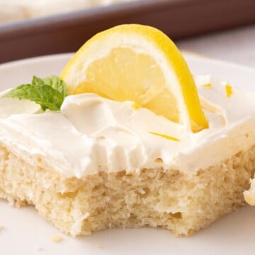 A slice of cake on a plate missing a fork bite.