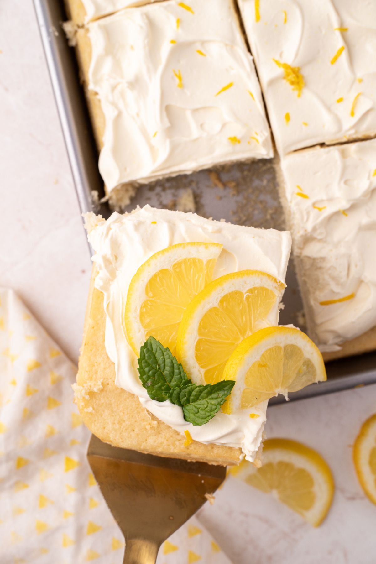 Slice of lemon cake with lemon slices and mint.