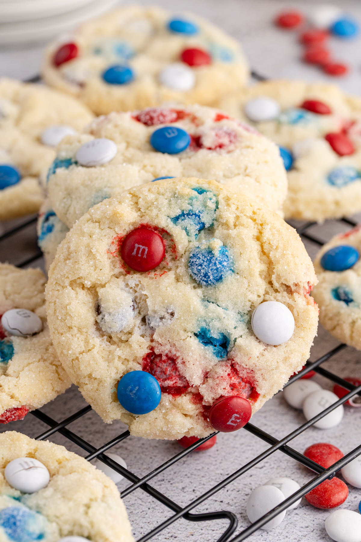A 4th of July sugar cookie leaned up against another with red, white and blue M&Ms.