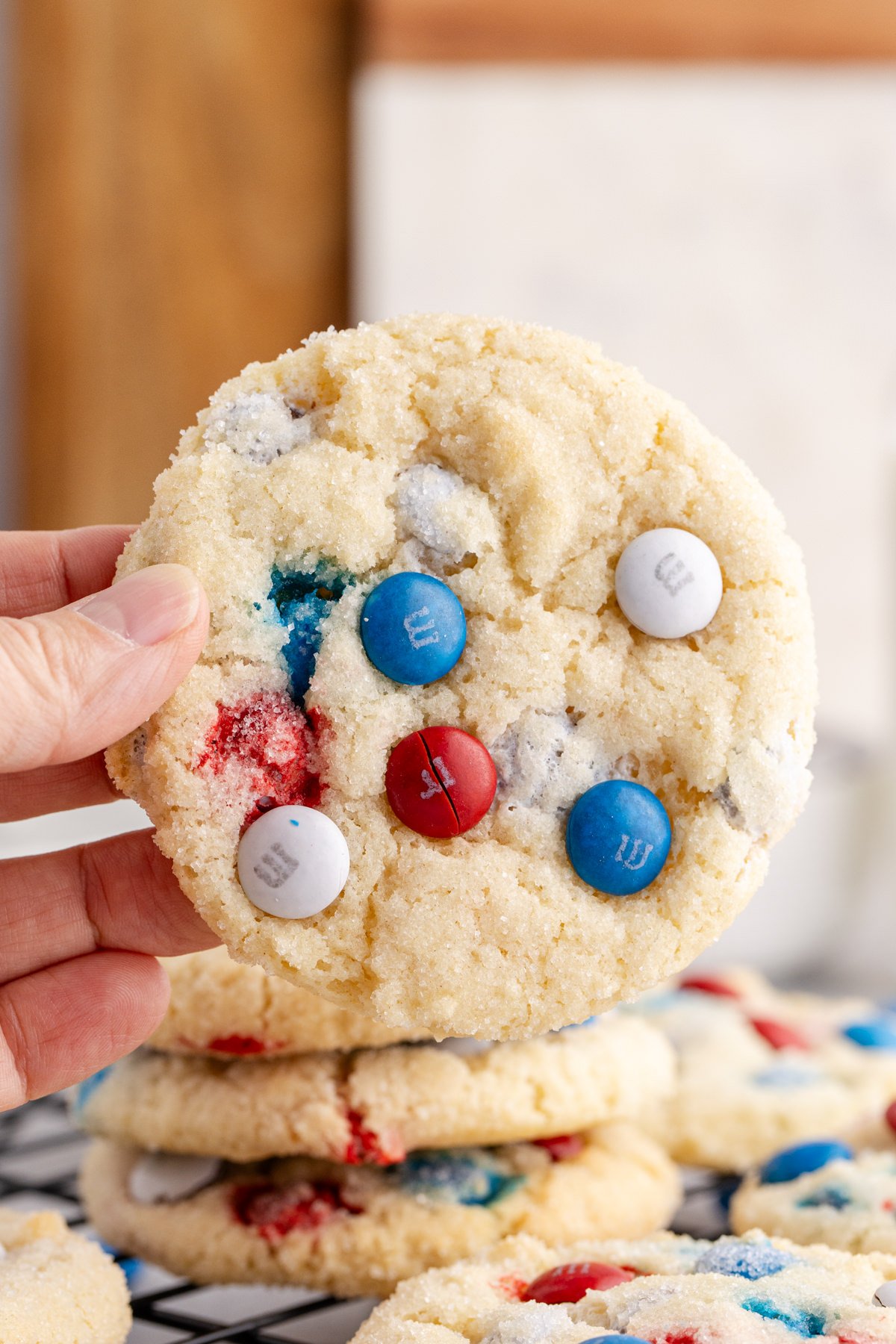 4th of july sugar cookie being held up in the air.