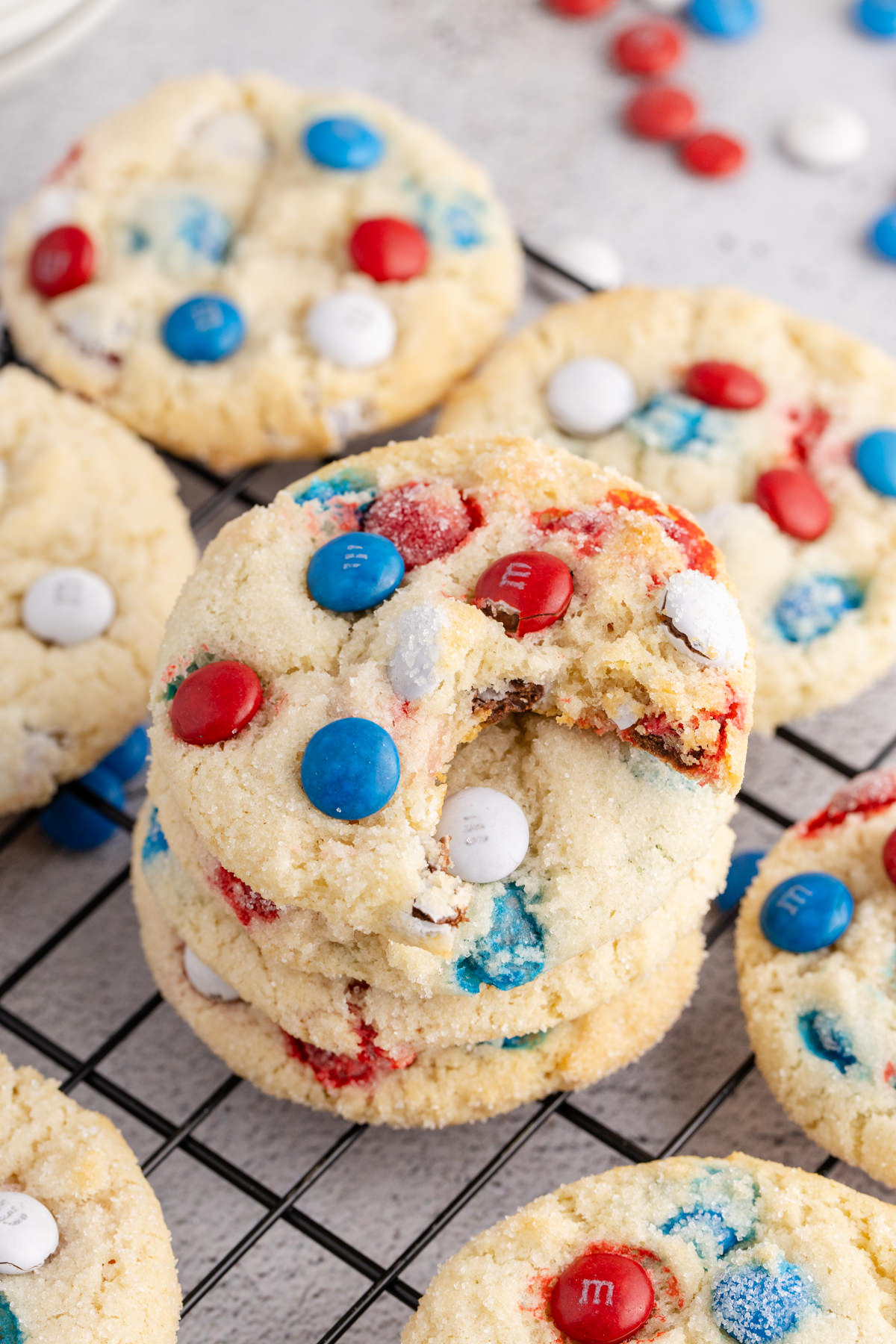 A stack of patriotic sugar cookies with a bite out of the one on top.