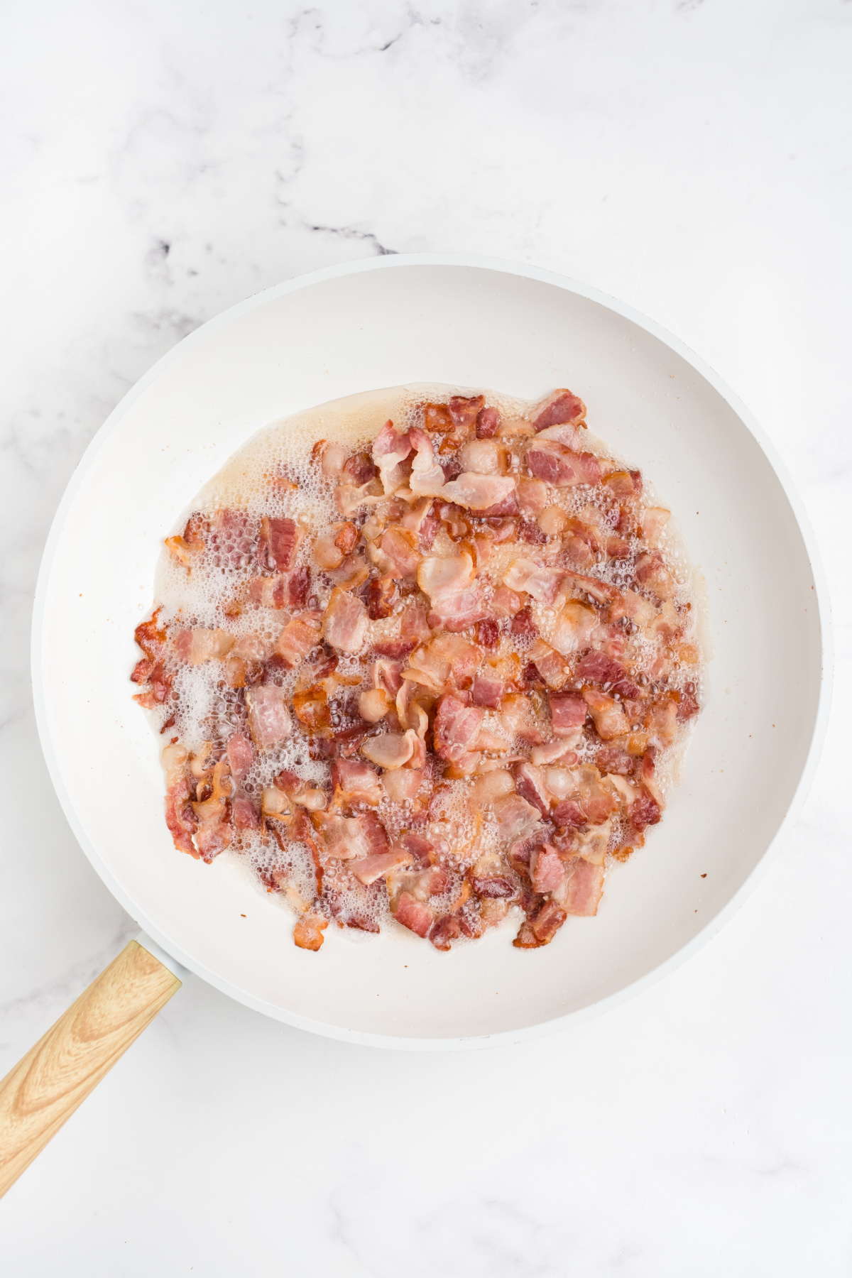 Bacon cooking in a skillet.