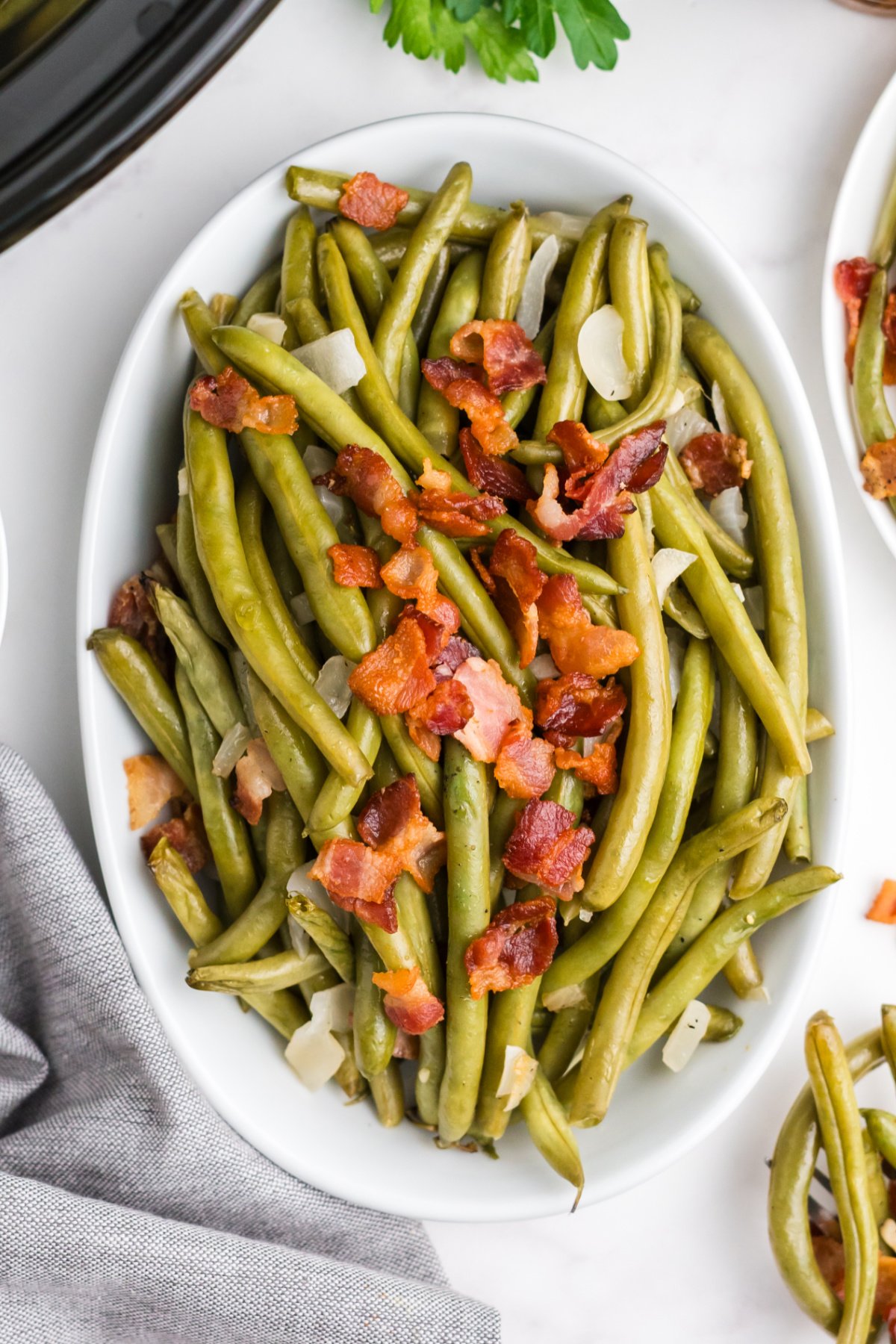 Crockpot green beans on a serving platter with bacon.