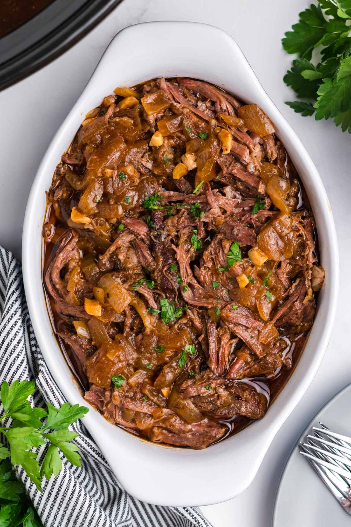 Shredded skirt steak with onions in a serving dish.