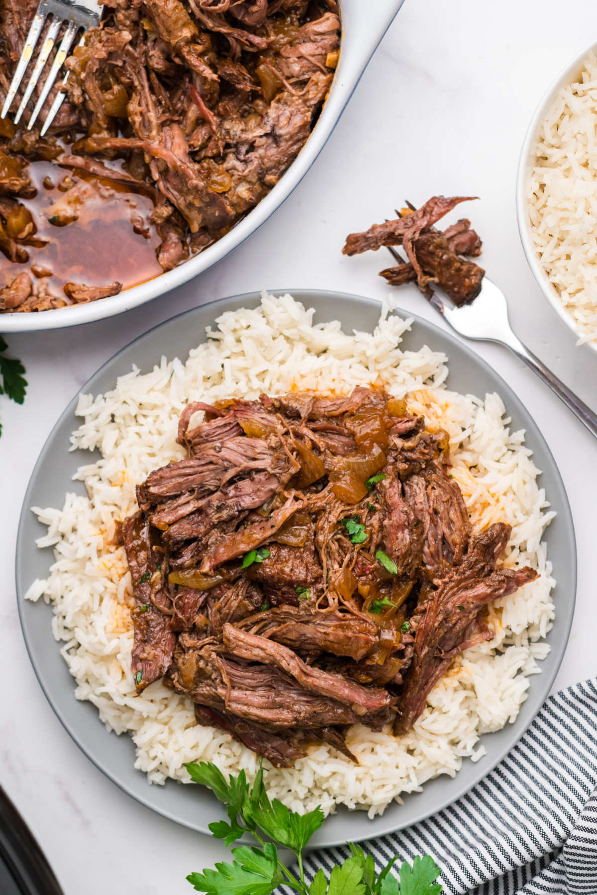 A large plate filled with shredded steak over white rice.