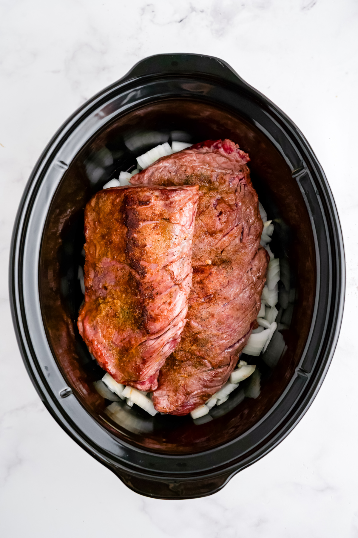 Onions, garlic, and steak in the slow cooker.